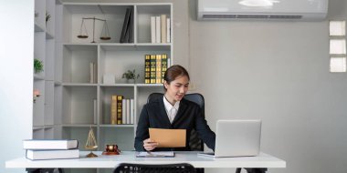 A lawyer works in an organized office decorated with legal symbols, focusing on careful evaluation and law-related tasks. clipart