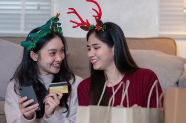 Lezbiyen çift keyifli bir tatil alışveriş seansının keyfini çıkarıyor. Teknolojiden birlikte neşeli anları paylaşmak için faydalanıyor..