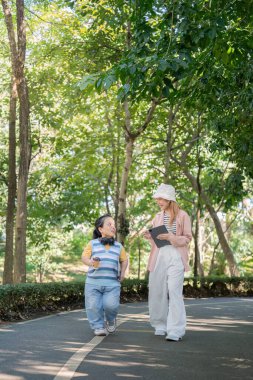 Two women enjoy a walk in the park, showcasing diversity and inclusion. One woman has achondroplasia, promoting awareness and understanding. clipart