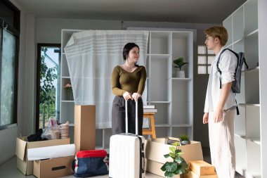 Genç bir çift yeni dairelerinde duruyor. Kutular ve bavullarla çevrili. Yeni bir bölüme başlamak için hazırlar..