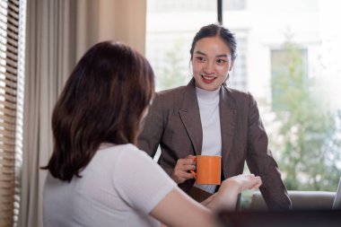 İki profesyonel, modern bir ofis ortamında kahve içerken hararetli bir tartışmaya giriştiler..