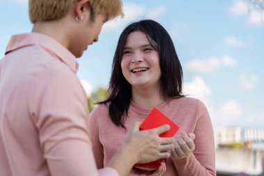 Sevgililer Günü 'nde açık havada içten bir hediyeyi paylaşan bir çift..