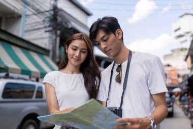 Bir çift canlı bir şehir pazarında keşif ve neşe dolu bir seyahat deneyimini paylaşıyor..