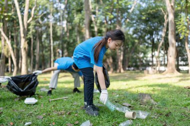 Family volunteers work together to collect garbage in a park promoting community involvement and environmental care. clipart