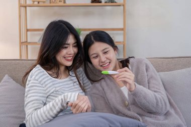 Lezbiyen bir çiftin rahat yuvalarında tüp bebek yoluyla hamileliği keşfetmesi için neşeli bir an..