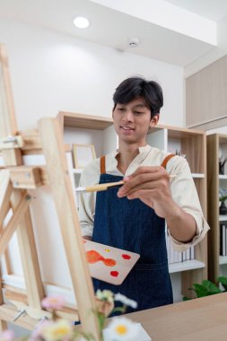 Ateşli bir stüdyoda resim yapan tutkulu bir sanatçı yaratıcılık ve odaklanma sergiliyor..