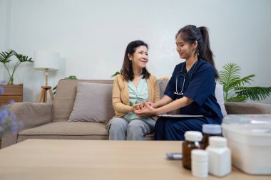 Bakıcı, yaşlı bir hastaya şefkatli bir evde semptomları kontrol etmesi için yardım eder..