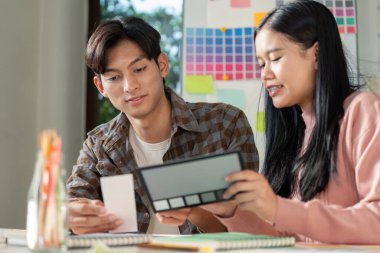 Bir tasarım ekibi, yenilikçi fikirleri ve görselleri canlı bir çalışma alanında harmanlayan grafikler üzerinde işbirliği yapar..