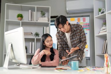 Yaratıcı çalışma alanındaki renkli çizelgeler aracılığıyla tasarım fikirlerini sergileyen işbirlikçi bir toplantı.