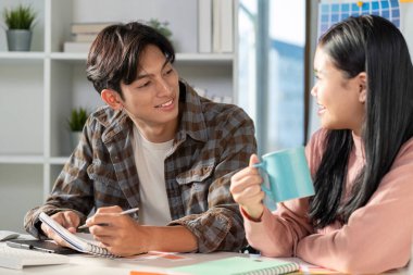 Parlak bir ofis ortamında canlı grafiklerle tasarım konseptleri üzerine ortak bir tartışma..