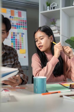 İşbirlikçi bir tasarım ekibi verimli bir toplantı sırasında canlı renk grafiklerini tartışır.