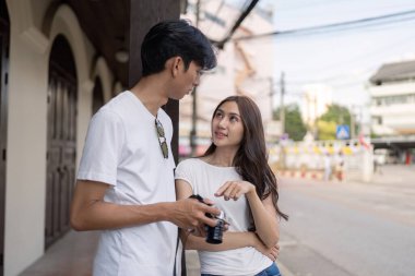 Bir çift, gezici anılarını canlı şehir sokaklarında bir kamerayla görüntülemekten zevk alıyor..