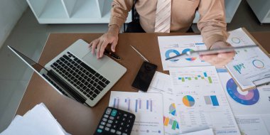 Modern ofis ortamında finansal raporların ve veri analizlerinin ayrıntılı bir incelemesi.
