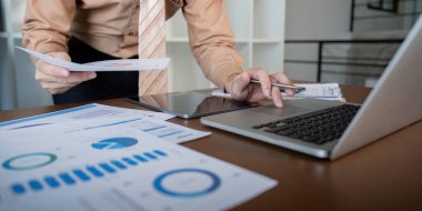 Finansal belgelerle çevrili bir tablet üzerinde grafik ve raporları analiz eden odaklanmış işadamı, karar verme sürecini optimize ediyor.