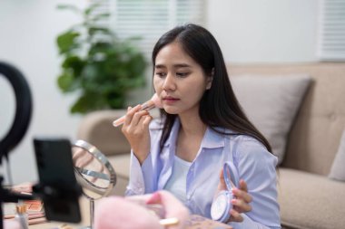 Bir güzellik komisyoncusu, canlı yayında seyircileriyle konuşurken ruj sürmeye odaklanmış makyaj tekniklerini ve ürün tavsiyelerini paylaşmış..