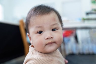 Çekici bir bebek kameraya tuhaf bir şekilde bakar, sıcak ve davetkar bir ortam ile çevrelenmiş, dikkat dağıtıcı bir şey olmadan..