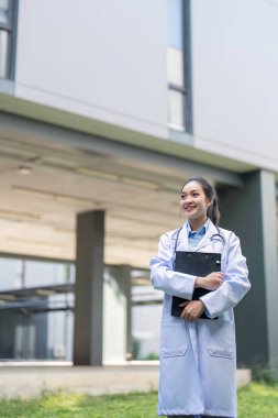 A smiling doctor stands confidently with a clipboard in hand, showcasing professionalism and readiness to assist patients in a healthcare setting. clipart