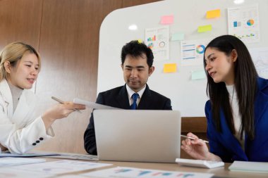 Çeşitli bir iş ekibi strateji toplantısına katıldı, raporları paylaştı ve analizleri tartıştı, çağdaş bir çalışma alanında etkili iletişim ve takım çalışmalarını vurguladı.