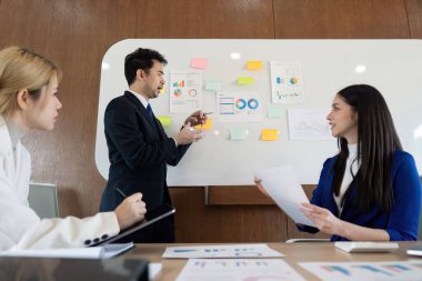 Finansal analiz, takım çalışması ve çağdaş bir çalışma alanında etkili iletişim üzerine bir sunum yapan çok kültürlü bir iş ekibi..