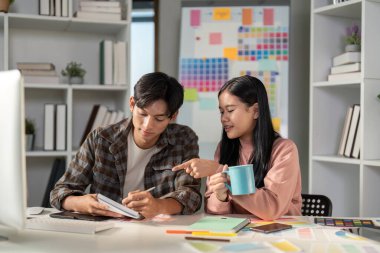 Modern bir çalışma alanında kahve içerken fikir alışverişinde bulunan çeşitli grafik tasarım ekipleri iş birliği ve beyin fırtınası yapıyor..