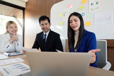 Çok kültürlü bir iş ekibi, bir tartışma sırasında görüşleri ve stratejileri paylaşıyor, çağdaş bir çalışma alanında işbirliği ve katılım sergiliyor.