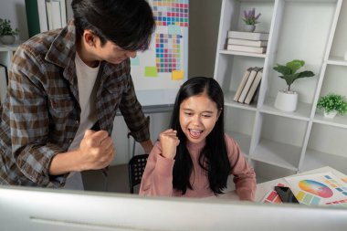 Çeşitli grafik tasarım ekibi proje başarısını ve başarılarını coşkuyla kutlarken aynı zamanda ilham verici bir çalışma alanında çalışıyor..