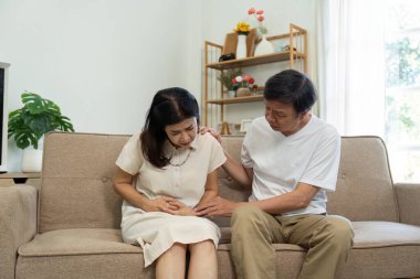 Kanepede oturan yaşlı bir çift, bir partnerinden rahatsızlığını dile getirirken diğeri ise rahatlık ve bakım sağlıyor..