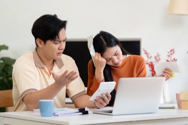 Bir çift evde gelir ve faturalarını hesaplıyor. Mali yönetimde endişe ve takım çalışması gösteriyor..