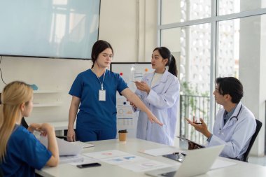 Bir hemşire ve doktor, hasta bakımını klinik bir ortamda değerlendirmek ve iyileştirmek için işbirliği yaparlar..