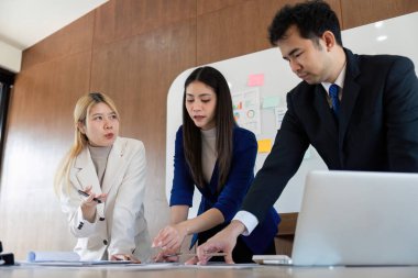 Profesyonel bir ekip, stratejik planlama ve analiz üzerinde işbirliği yaparak mali raporları ve çizelgeleri gözden geçiriyor..