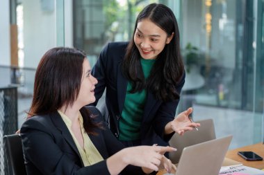 Finansal planlama ve strateji hakkında görüşlerini paylaşan iki bayan meslektaşı, etkili bir takım çalışması ve işbirliği sergilediler..