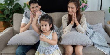 Mutlu bir aile birlikte kutlama yapar. Kızları heyecan içinde elini kaldırır. Sevgisini ve beraberliğini gösterir..