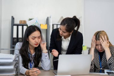 Üç kadın mali stratejileri tartışırken ve verileri analiz ederken, takım çalışmasının zorluklarını vurguluyor.