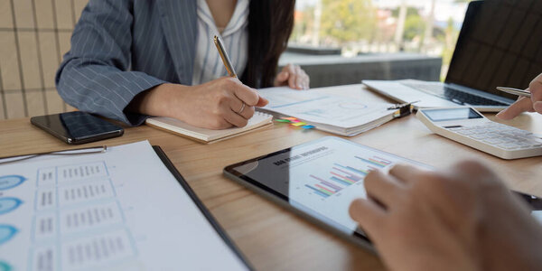 Professionals work together on financial documents, showcasing teamwork and strategic planning in a modern workspace.