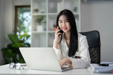 Genç bir kadın mali belgeleri incelerken vergi dosyalarını hazırlıyor, çalışkanlık ve profesyonellik gösteriyor.