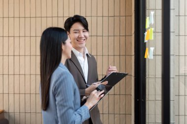 Profesyonel bir ekip, dizüstü bilgisayardaki proje sonuçlarını incelerken başarılarını birlikte kutluyor..