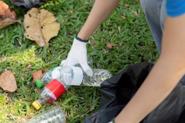 Adanmış bir gönüllü yerden plastik şişeler topluyor, sürdürülebilir bir çevreye katkıda bulunuyor ve geri dönüşüm çabalarını destekliyor.