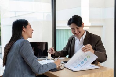 İlham verici bir ofis ortamında, iki profesyonel gülücüklerini paylaşıyor ve stratejik büyüme için finansal içgörüler üzerine neşeli bir tartışmaya girişiyorlar..