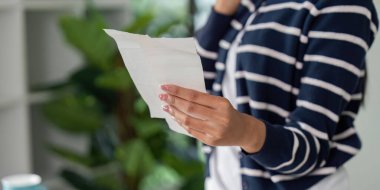 Bir kişi telefon görüşmesi sırasında kişisel finans yönetimini vurgulayan bir tasarıyı inceler.