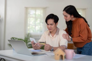 Genç bir çift finansal tartışmalara giriyor, bütçelerini gözden geçiriyor ve ev ortamında birbirlerine destek oluyorlar..