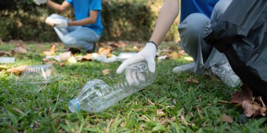 Parkta plastik atık toplayan bir kişi, sürdürülebilirliğin ve toplumsal eylemin önemini vurgularken görülüyor.