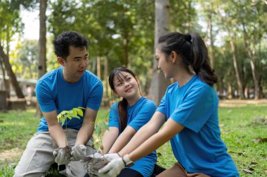 Bir ağaç dikme girişimine aktif olarak katılan kendini adamış bir grup gönüllü daha yeşil bir geleceğe gülümseme ve bağlılıklarını paylaşıyor..