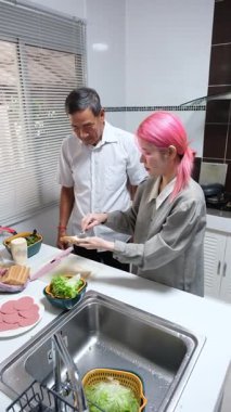 Büyükbaba ve torun birlikte mutfakta kaliteli zaman geçiriyorlar, neşe ve takım çalışması ile atıştırmalık hazırlıyorlar..