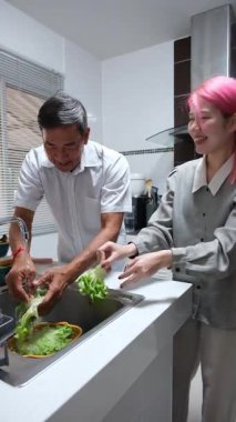 Büyükbaba ve torun birlikte mutfakta kaliteli zaman geçiriyorlar, neşe ve takım çalışması ile atıştırmalık hazırlıyorlar..