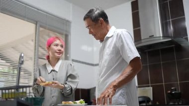 Büyükbaba ve torun birlikte mutfakta kaliteli zaman geçiriyorlar, neşe ve takım çalışması ile atıştırmalık hazırlıyorlar..