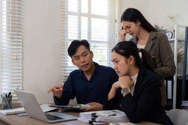 İşbirlikçi bir ortamda, bir ekip üyesi bir konuyu açıklarken, diğerleri dikkatle dinleyip sorunları çözmek için net iletişim gereğini vurguluyor.