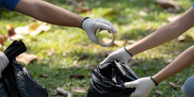 Gönüllüler bir araya gelerek atık toplama, takım çalışmasını sembolize etme ve toplumu temizleme gününde sürdürülebilirliğe olan bağlılığı sembolize etme amaçlı materyaller dağıtırlar..