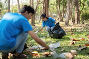 Adanmış gönüllüler, sürdürülebilir uygulamaların ve çevreyi temiz tutmadaki toplumsal katılımın önemini gözler önüne sererek, parkta çöpleri temizlemek için birlikte çalışıyorlar..