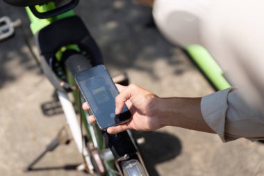 Bisikletçi, kentsel alanlarda sürdürülebilir taşımacılığın faydalarını sergileyerek, çevre dostu alışkanlıkları teşvik ederek teknolojiyle meşgul oluyor..