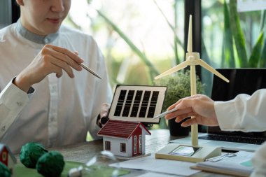 Stratejik bir toplantıda çevre dostu konut çözümleri ele alınırken, profesyoneller güneş ve rüzgar teknolojilerinin sürdürülebilirliği nasıl geliştirebileceğini inceliyor.